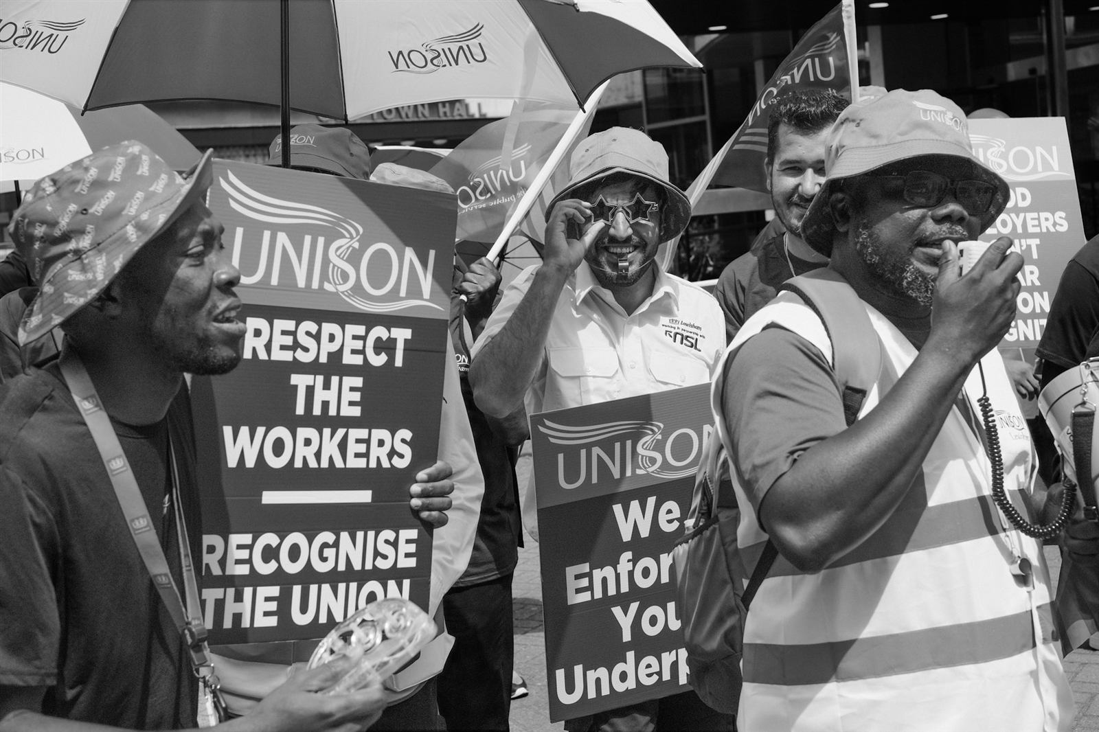 UNISON workers on a picket line outside Lewisham Town Hall, holding Respect the Workers, Recognise the Union placards